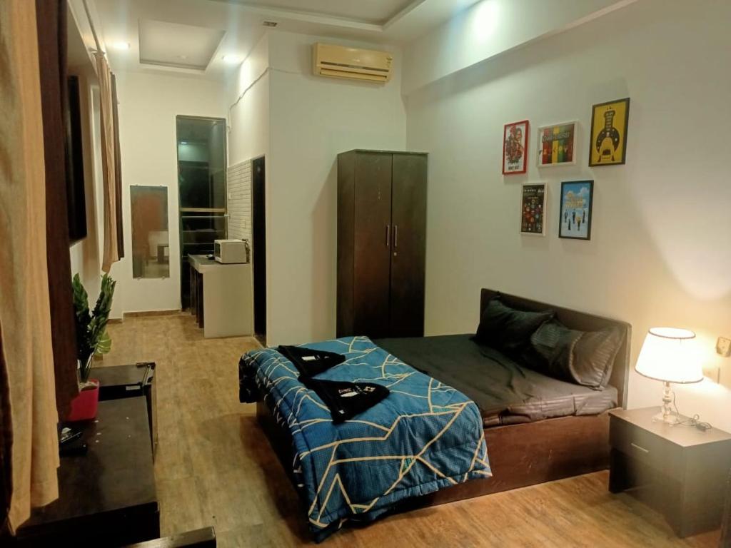 a living room with a bed and a couch at Ivy Pali Studio Rooms (Near Imagica), Dhokshet in Jambhulpāda