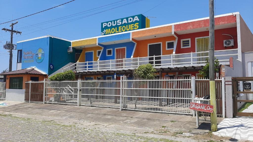 een gebouw met een hek ervoor bij Residencial dos Moleques in Capão da Canoa
