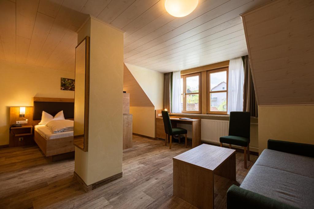 ein Hotelzimmer mit einem Bett und einem Schreibtisch in der Unterkunft Gasthof Hotel Reif in Königstein in der Oberpfalz