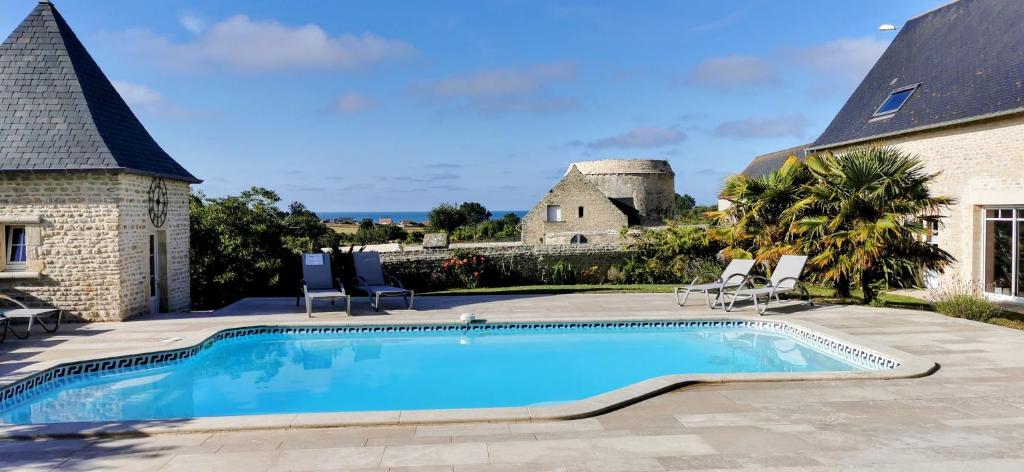 - une piscine en face d'une maison dans l'établissement Villa Gold Beach, à Saint-Côme-de-Fresné