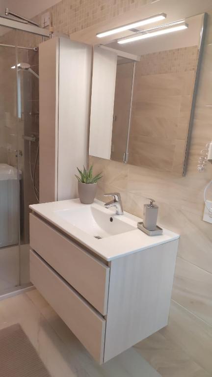 W łazience znajduje się biała umywalka i lustro. w obiekcie CASA VACANZE DA GABRI w mieście Tirano