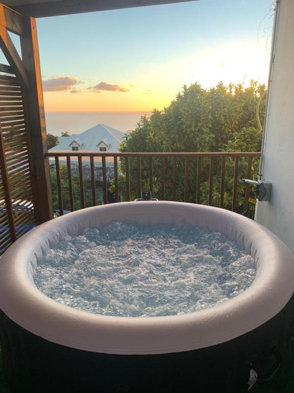 bañera de hidromasaje en el balcón con vistas al océano en Villa Karata Appartement T3 avec Spa et vue sur mer BAILLIF Basse-Terre, en Baillif
