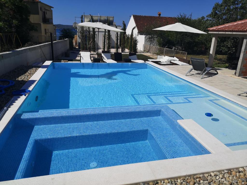 uma piscina com água azul numa casa em Villa Lukas em Sukošan