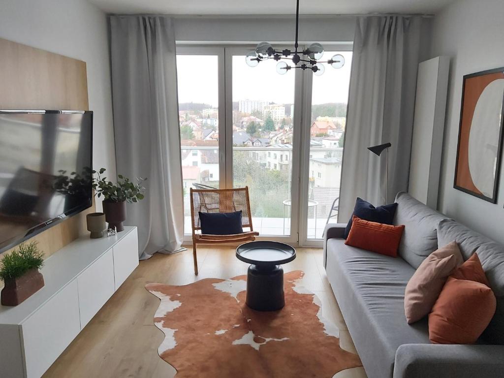 sala de estar con sofá y ventana grande en Apartament Harmony 93 en Gdynia