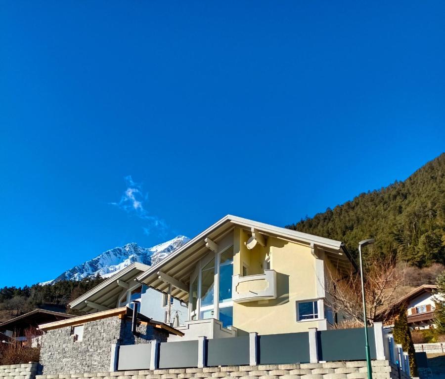 ein Haus mit den Bergen im Hintergrund in der Unterkunft Apart Schranz in Grins