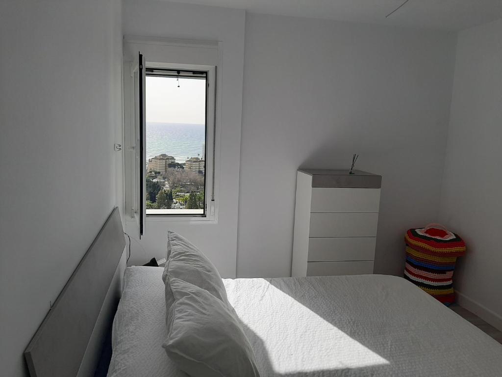 biała sypialnia z łóżkiem i oknem w obiekcie Arroyo mar & montaña cozy place w mieście Benalmádena