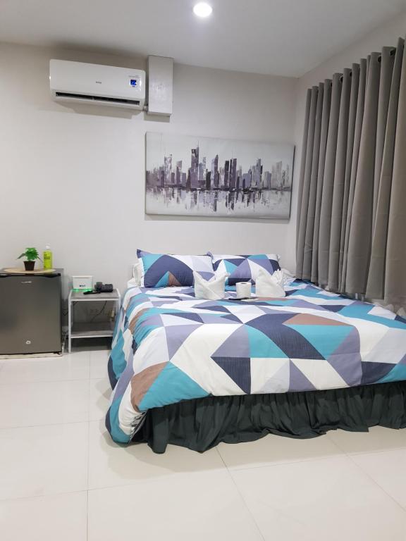 um quarto com uma cama com um cobertor azul e branco em Skymagz 812 at Cityscape Residences em Bacolod