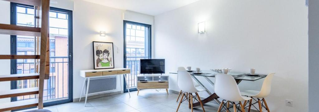 uma sala de jantar com uma mesa e cadeiras brancas em 302 - Appartement Duplex Moderne - Jeanne d'Arc, Toulouse em Toulouse