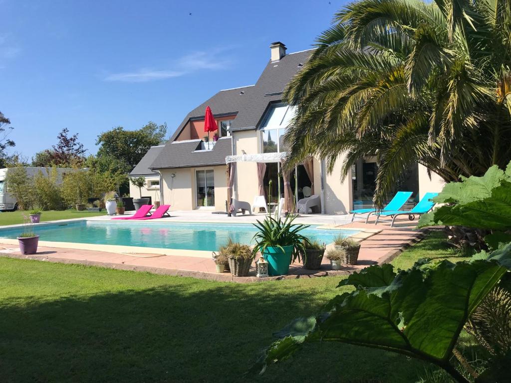 a house with a swimming pool in the yard at Belle villa bord de mer avec piscine in Urville-Nacqueville