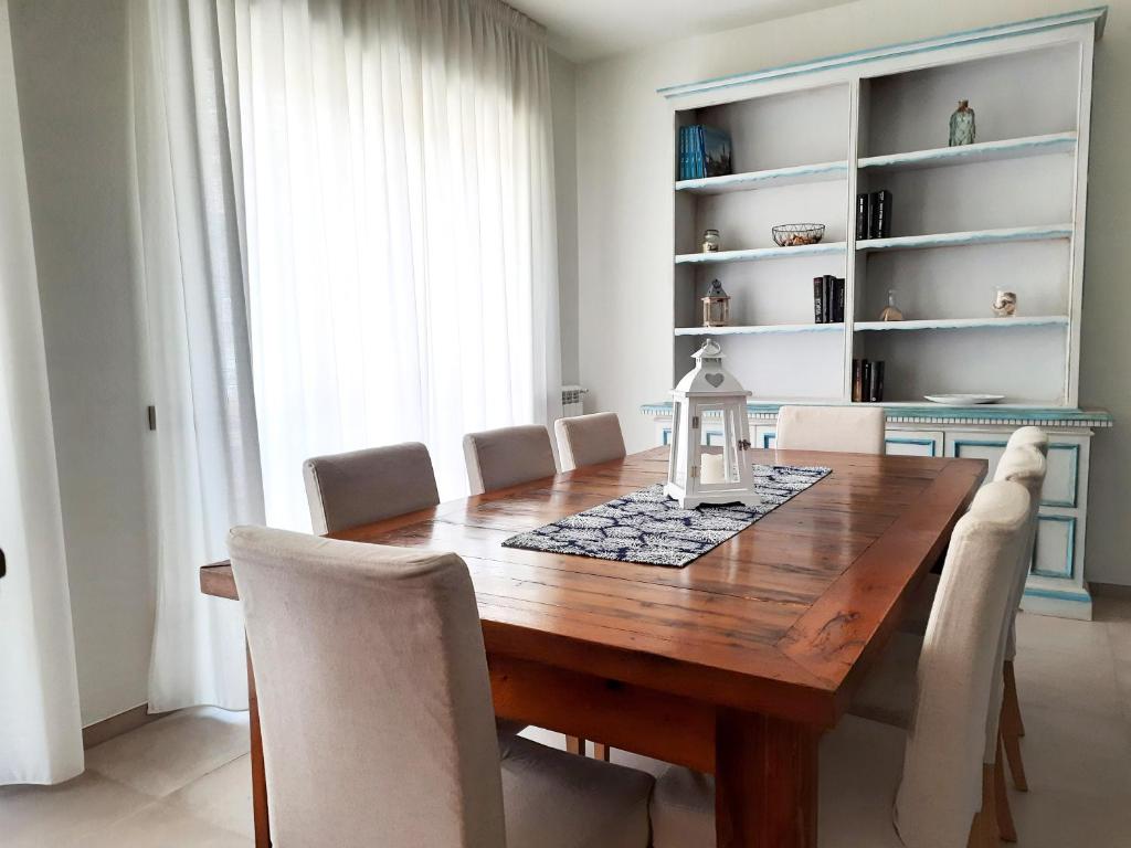 Un comedor con mesa y sillas de madera. en Casa di Nicola, en Viareggio