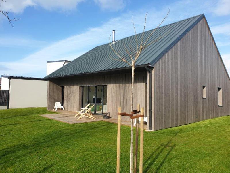 a building with a tree in front of it at Villa des Dunes in Gouville-sur-Mer