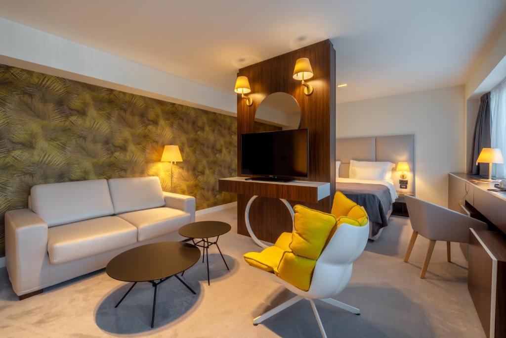 Habitación de hotel con sofá y cama en HOTEL AGAPE, en Bar