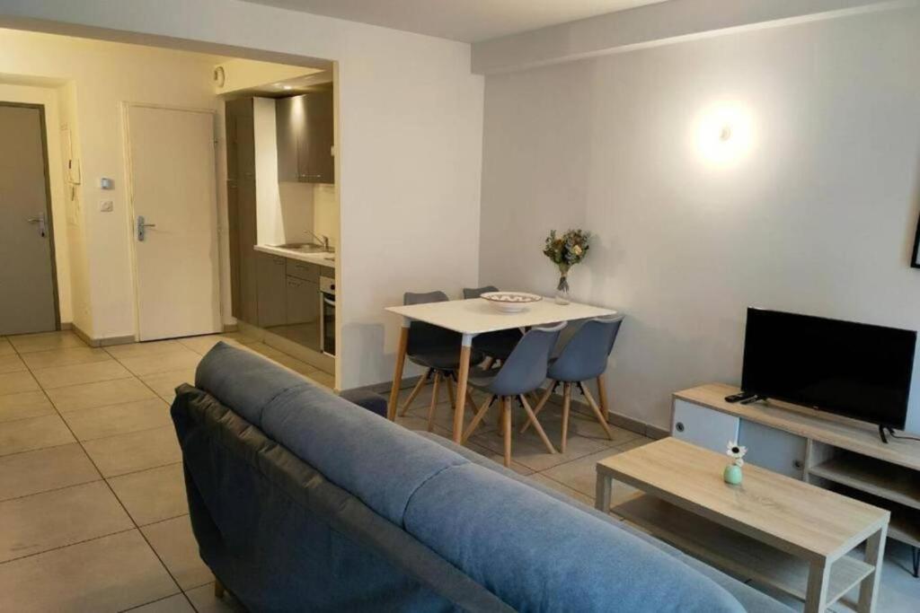 a living room with a blue couch and a table at 203 Duplex Jeanne d'Arc in Toulouse