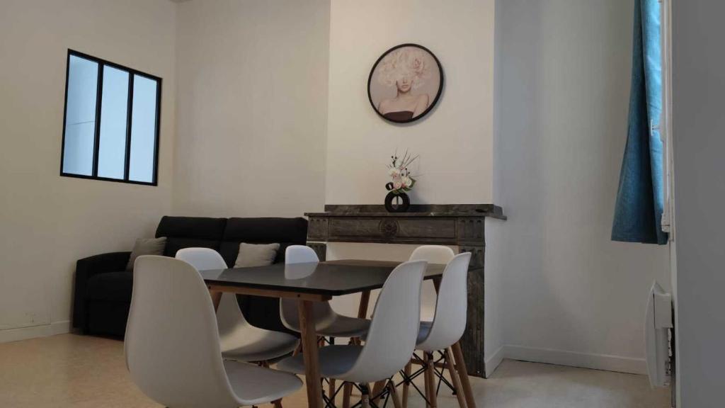 ein Esszimmer mit einem Tisch und weißen Stühlen in der Unterkunft Appartement 7 - T3 70m2 - Standing, moderne et tout équipé - Carmes-Renforts , Toulouse in Toulouse