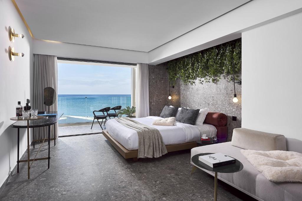 a bedroom with a bed and a view of the ocean at Dyo Suites in Rethymno Town