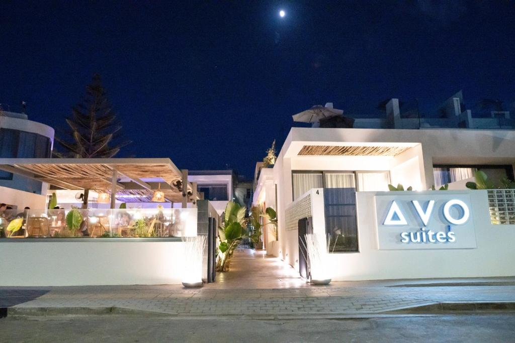 a white building with aiya suites sign in front of it at night at Dyo Suites in Rethymno