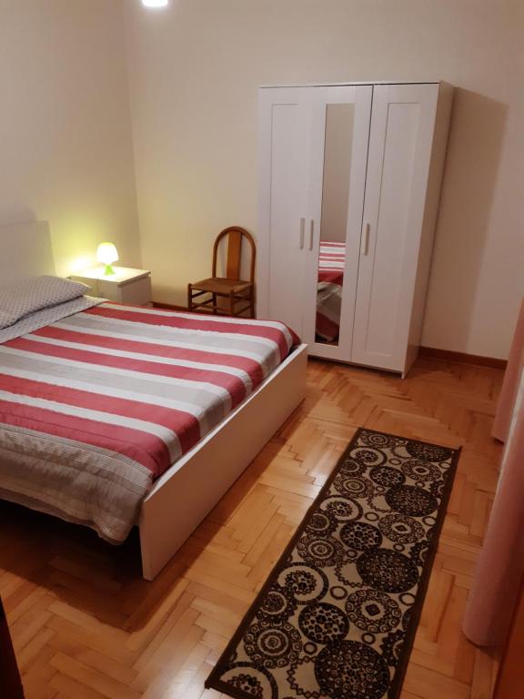 una camera con letto, specchio e tappeto di Miniappartamento Singolo a Padova