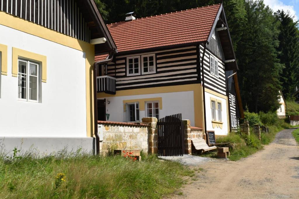 a house with a bench in front of it at Hlucov - Penzion & Restaurace - in Kaninský Dŭl