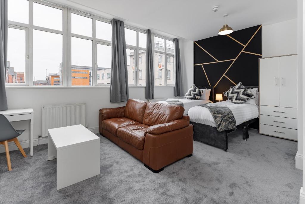 a hotel room with a bed and a couch at City Centre Studio 7 with Kitchenette, Free Wifi and Smart TV by Yoko Property in Middlesbrough