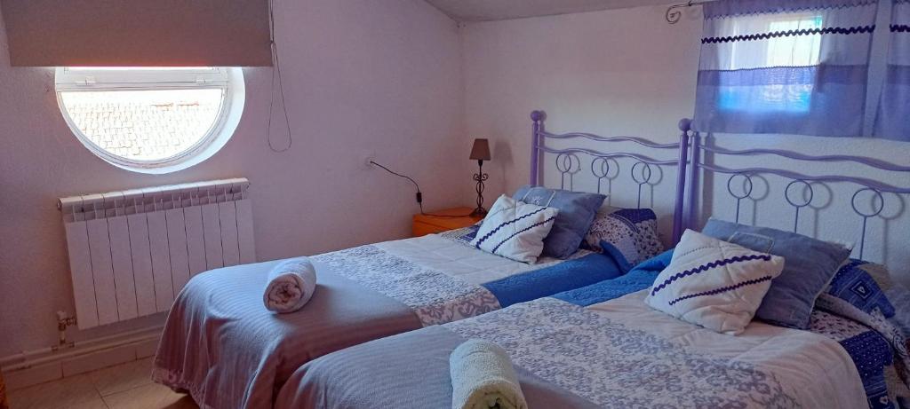 1 dormitorio con 2 camas y ventana en EL DESVÁN, en Santa Marta de Tormes