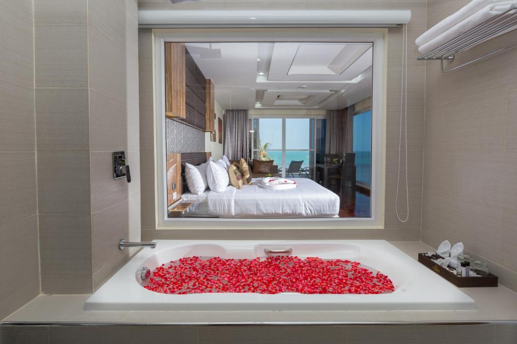 Un pat sau paturi într-o cameră la Royal Beach Boutique Resort & Spa Koh Samui