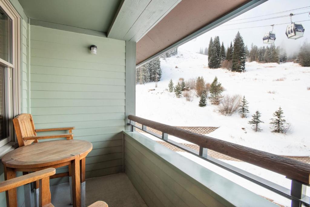 uma varanda com uma mesa e vista para uma montanha coberta de neve em Beautiful Zephyr Mountain Lodge condo with Slope Base View condo em Winter Park