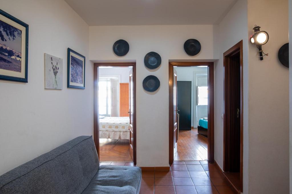 a living room with a couch and plates on the wall at Casa da Avó Alsira 2 in Évora