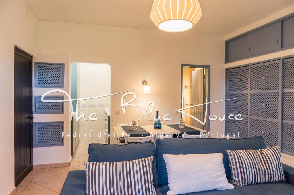 a living room with a blue couch and a mirror at The Blue House, Pedras D'el Rei, Tavira in Tavira