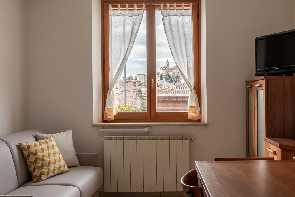 - un salon avec un canapé et une fenêtre dans l'établissement Casa in Chiana, à Torrita di Siena