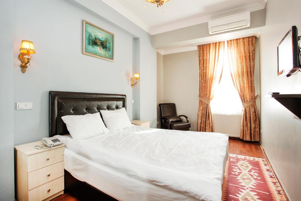 イスタンブールにあるSheriff Royal Suiteのベッドルーム1室(ベッド1台、椅子、窓付)