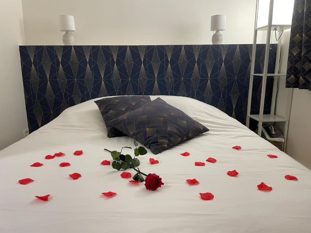 Un mazzo di rose rosse su un letto con un cuscino di Houlgate Appartement La Briarde a Houlgate