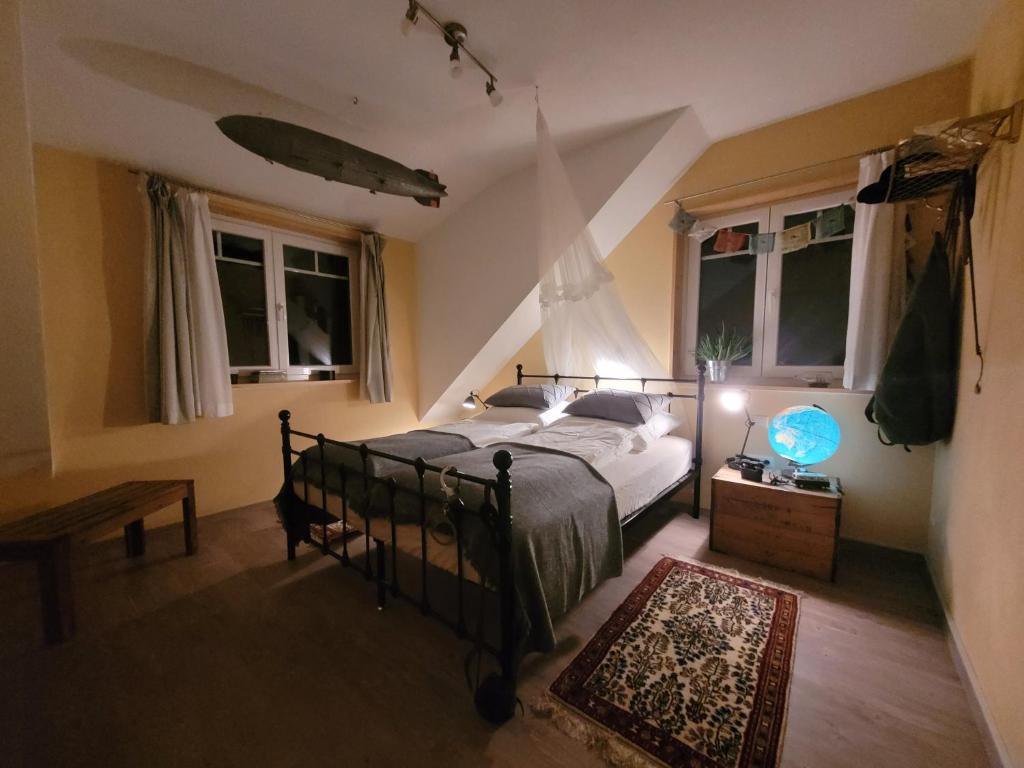 een slaapkamer met een bed en 2 ramen bij In der alten Gärtnerei B&B in Neuhof an der Zenn