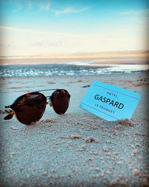 a pair of sunglasses and a sign on the beach at Hôtel Gaspard in Le Touquet-Paris-Plage