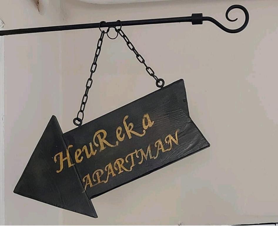 a sign for a restaurant hanging from a chain at HeuReka Apartman in Pécs