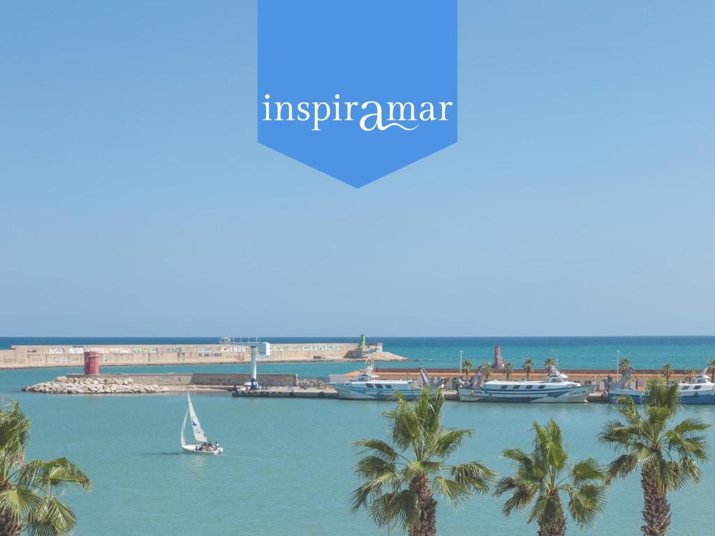 a sail boat in the water with palm trees at inspiramar in Benicarló