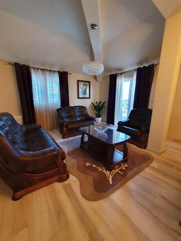 a living room with leather furniture and a coffee table at Apartmani Tip-Top in Tivat