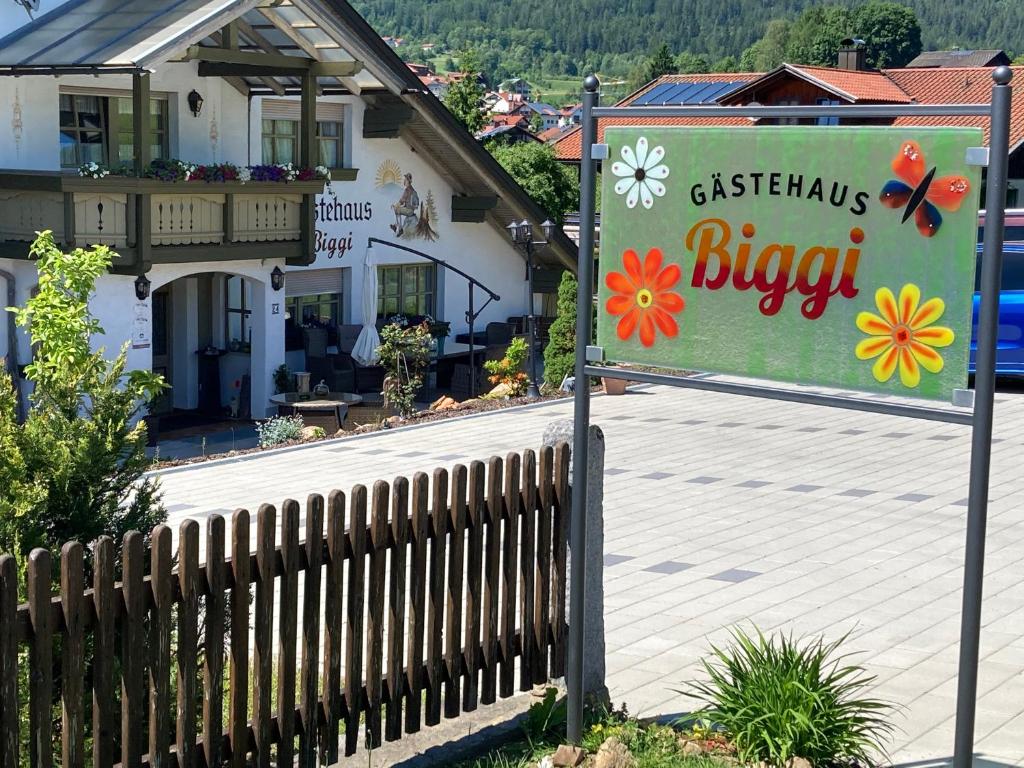 a sign in front of a house with a fence at Gästehaus Biggi in Bodenmais