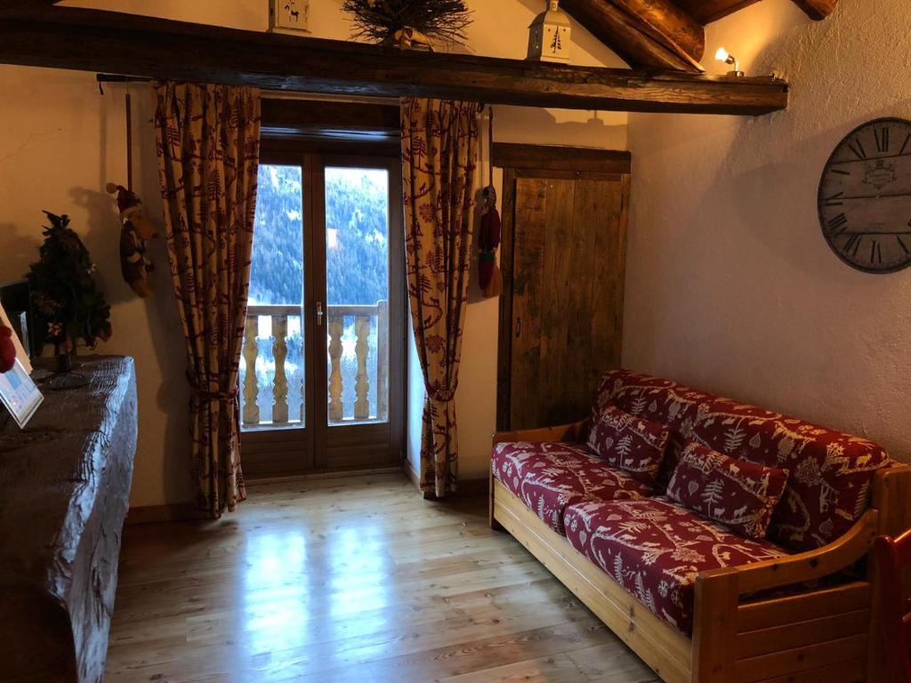 un soggiorno con divano e una grande finestra di CHALET DI MONTAGNA, Valtournenche-Cervinia a Valtournenche