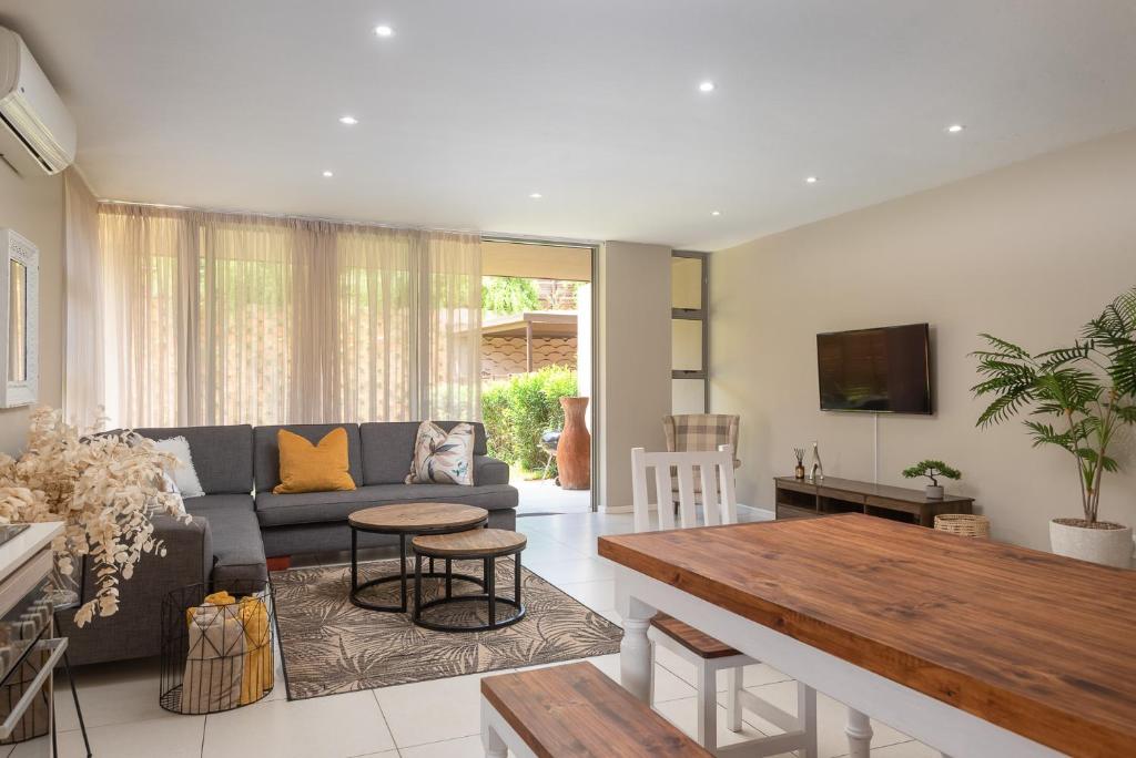 uma sala de estar com um sofá e uma mesa em Zimbali Wedge Unit 42 em Ballito