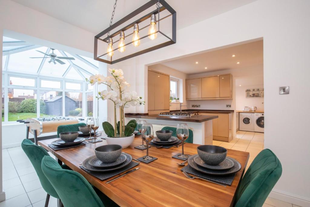 a kitchen and dining room with a wooden table and chairs at Modern Three Bedroom Gloucester Home in Gloucester