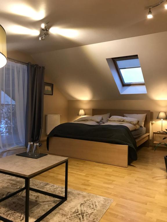 um quarto com uma cama grande e uma clarabóia em ,,Įlanka" em Rumšiškės