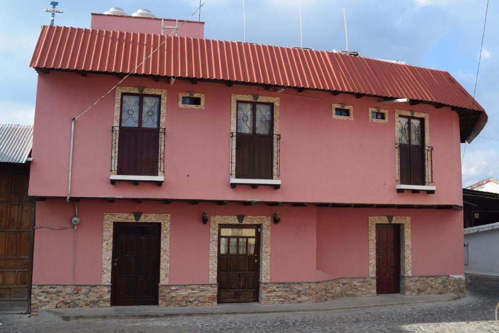 una casa rosa con techo rojo en Hotel California, en Mineral del Monte
