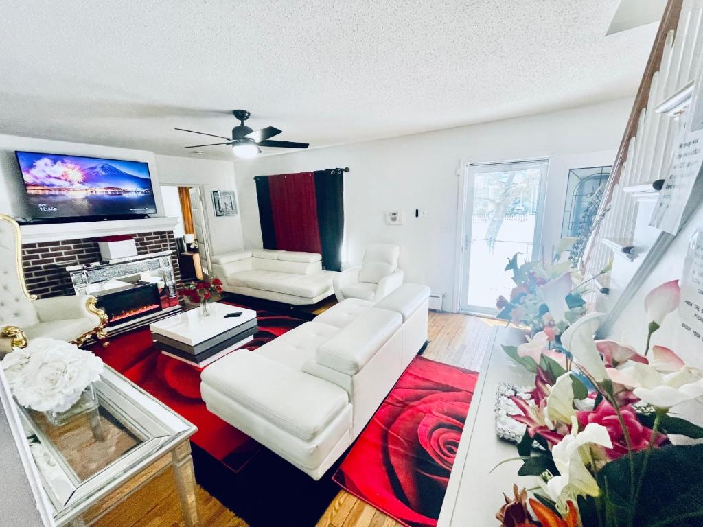 a living room with white furniture and a flat screen tv at Fearlessrose vacation Rental in Springfield