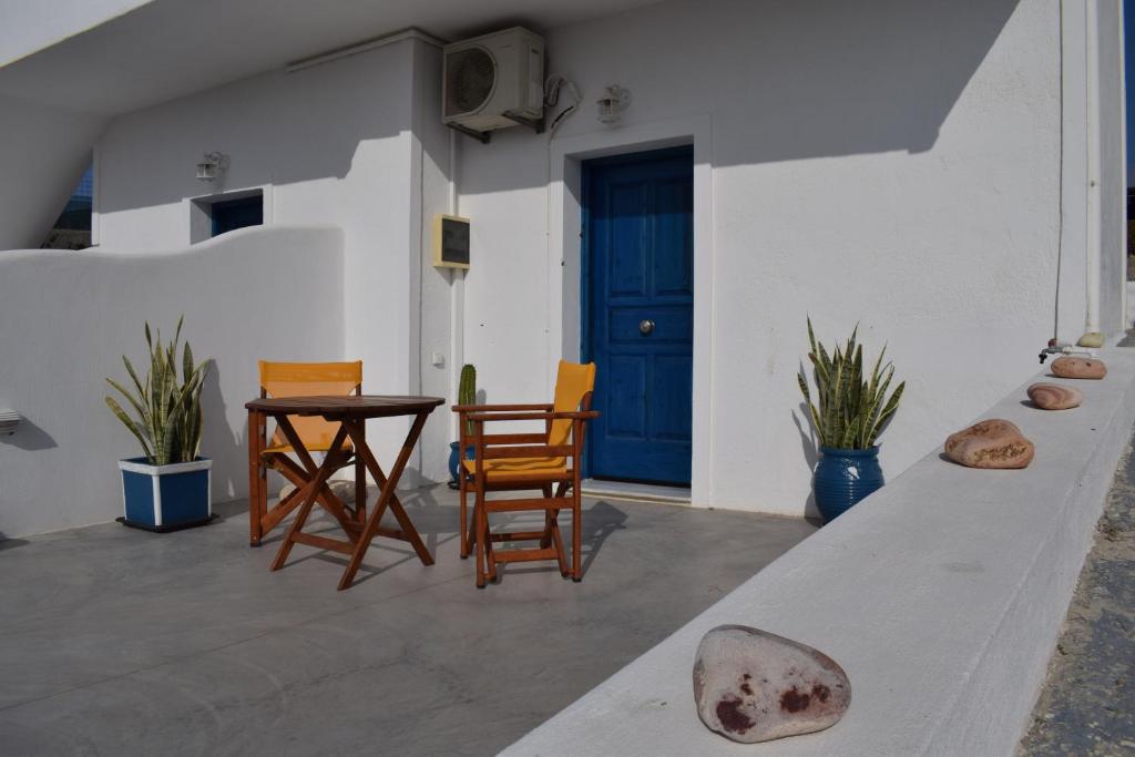 a patio with chairs and a table and a blue door at ONAR STUDIOS MILOS Junior in Adamantas
