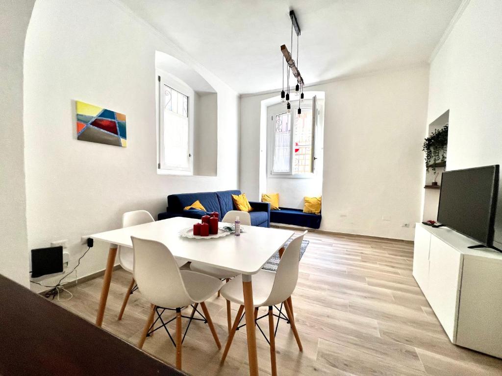 a dining room and living room with a white table and chairs at La casa di Ale nel centro storico di Cagliari in Cagliari