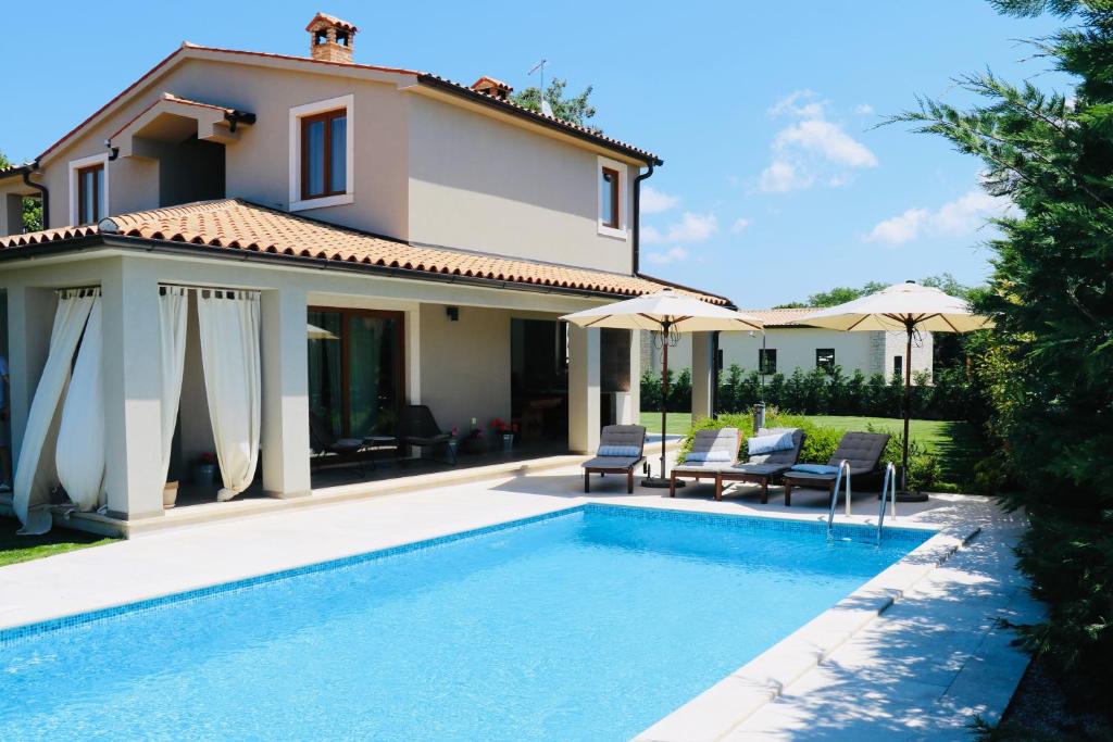 eine Villa mit einem Pool und einem Haus in der Unterkunft Villa Stoje - mit beheiztem Pool in Svetvinčenat