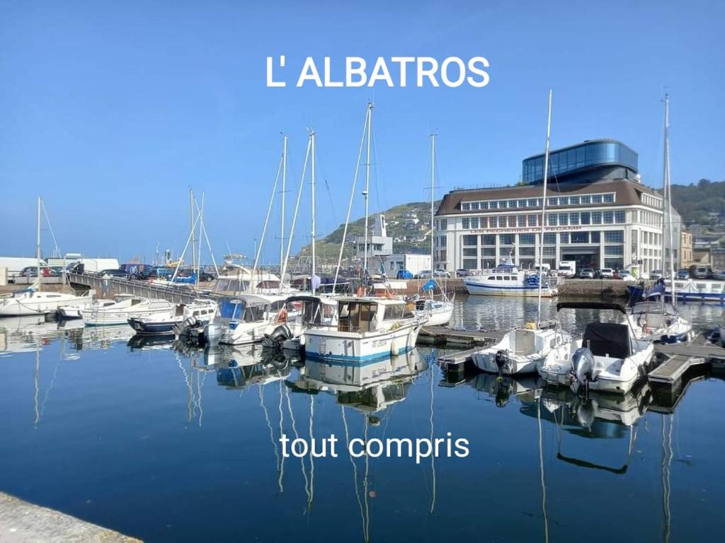 a group of boats docked in a marina with a building at L' ALBATROS vue sur le port in Fécamp
