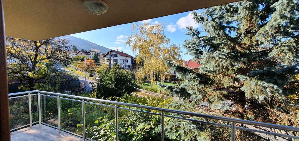 a balcony with a view of a house and trees at ALBISTO Dragalevtsi Luxury Apartments in Sofia