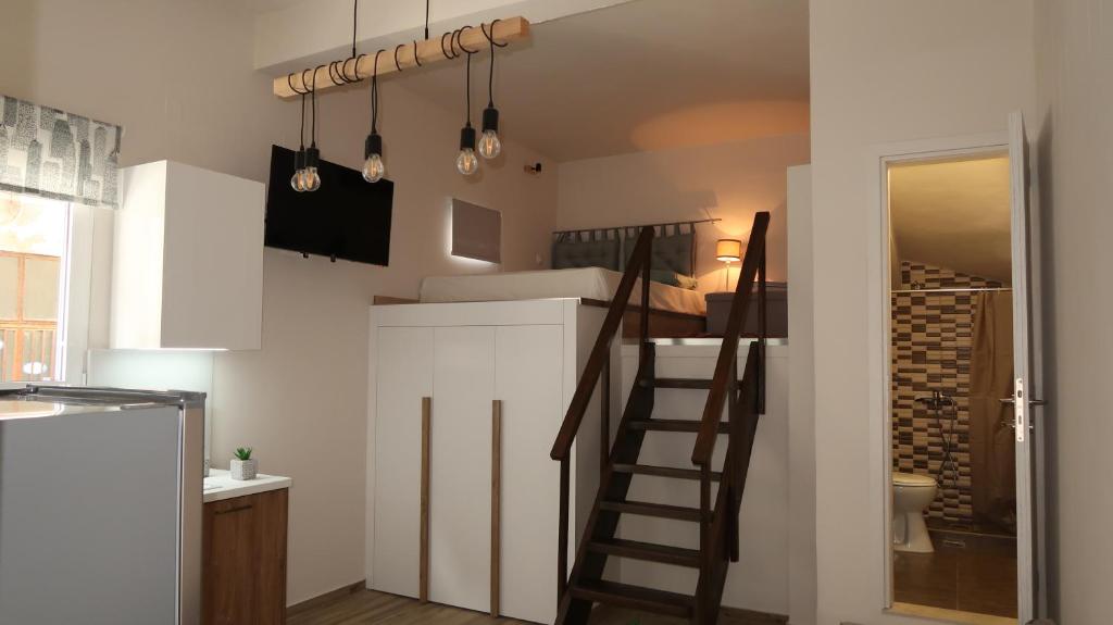 uma cozinha com uma escada que leva a um loft em Cozy apartment near the city centre em Iráclio
