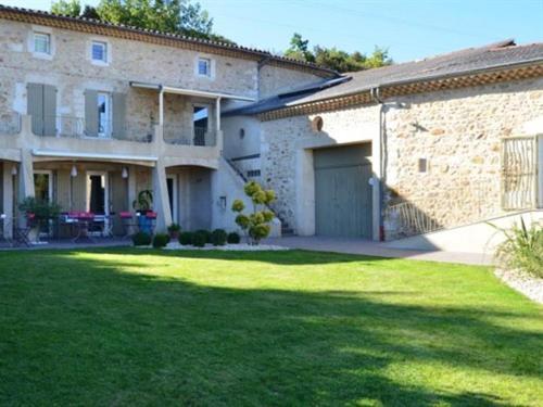 une grande maison en briques avec une cour avec une pelouse dans l'établissement Coeur de Vignes, à Saint-Péray